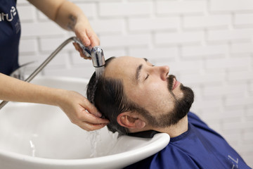 39-year-old man washes hair in a hairdressing salon