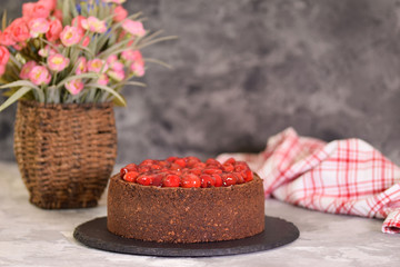 Delicious homemade chocolate cheesecake decorated with cherry sauce.