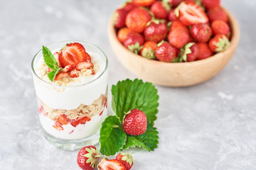 Strawberry granola or smoothie in glass and fresh berries in a wooden bowl. Healthy breakfast