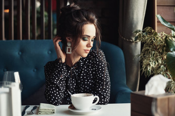 Woman drink coffee at the table in the restaurant or cafe