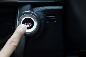 Pressing the button to start a car.