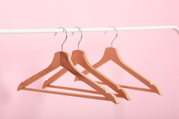 empty clothes hangers on a wardrobe rack on a colored background. - obrazy, fototapety, plakaty