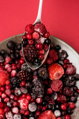 Cuchara con frutos rojos congelados para smoothie sano: arándanos, moras, fresas... Dieta vegana 