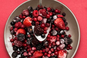 Cuchara con frutos rojos congelados para smoothie sano: arándanos, moras, fresas... Dieta vegana 