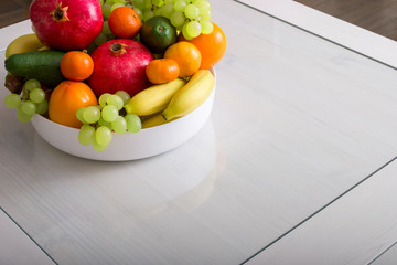 Delicious fresh fruits in plate on table, copy space.