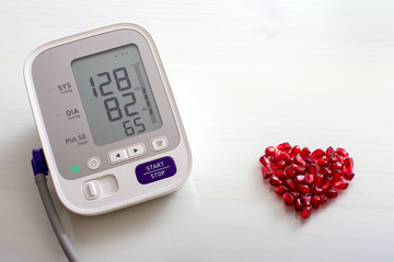 Blood pressure monitor with result of measurement, fresh fruits with vegetables and tape measure,...
