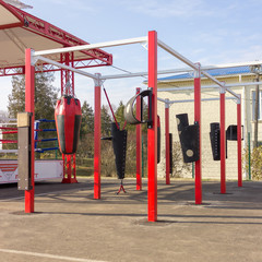 Image of an outdoor training room with punching bags of various shapes for martial arts. Healthy lifestyle concept.