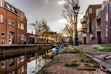 Traditional old buildings, canal and  boat the sunset in Leiden, Netherlands