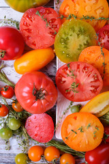 Red, orange, yellow and green tomatoes of different sorts. Assortment of sliced and whole tomatoes