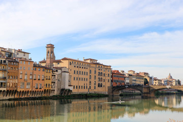 Fototapeta na wymiar View to embankment of Arno river with bridge and medieval buildings, Florence, Italy