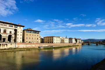 Fototapeta na wymiar amazing view to arno river and medieval houses in florence under bright blue winter sky