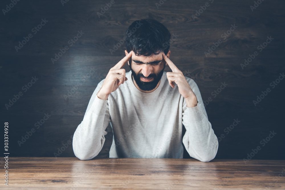 Wall mural .sad man hand on head on dark background