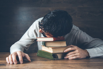 sad man head on book on desk