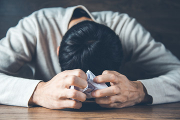 sad man hand crumpled paper