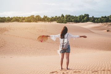 Young woman traveler walking at red sand dunes in Vietnam, Travel lifestyle concept