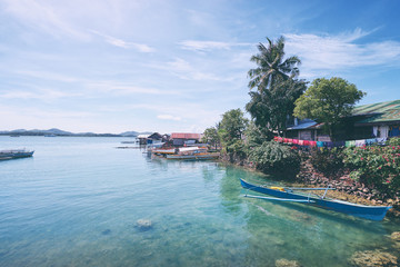 Fototapeta na wymiar Beautiful landscape with blue sea, tropical islands and fishing houses on stilts in mangrove lagoon, Siargao Island, Philippines.