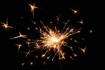 Fototapeta premium Fire spark xmas with black background. Magic glowing flow of sparks in the dark. Sparkler