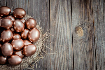 Obraz premium Background with Golden Easter eggs on wooden background.