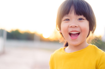 Happy Little asian girl child showing front teeth with big smile and laughing: Healthy happy funny smiling face young adorable lovely female kid.Joyful portrait of asian elementary school student.