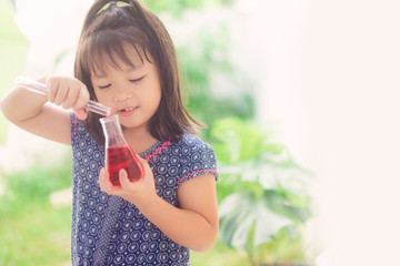 Happy Little scientist asian girl with red liquid into flask and shaking on white background.Home...