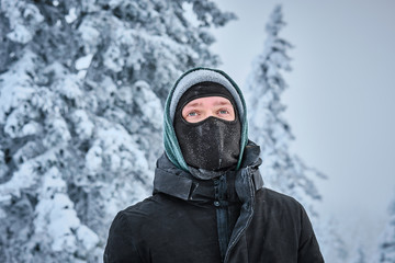 Fototapeta na wymiar Man in mask standing in the snowy winter forest