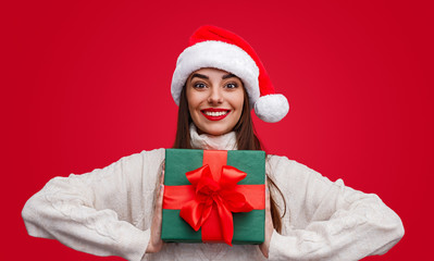 Glad woman with wrapped Christmas gift