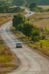 Obraz na płótnie Canvas Car rides on a road in the mountains, summer season.