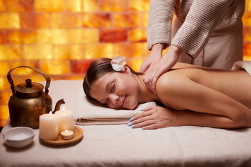 Relax and enjoy spending time in spa salon, getting massage by professional masseur. Woman lying with naked back and relax on table for massage