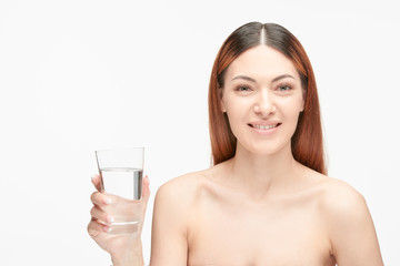 Portrait of a beautiful young woman with glass of water