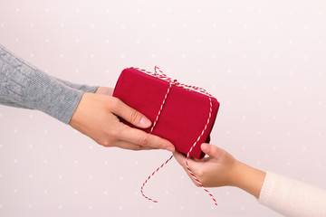 Hands of an adult giving a gift to a child. Christmas, New Year, Birthday