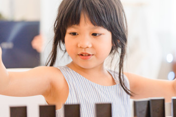 Bonding time! Father and his asian child girl are playing at home.Cute little asian girl play math game with her dad, sitting on the table at home office in Holiday.Family holiday and togetherness.