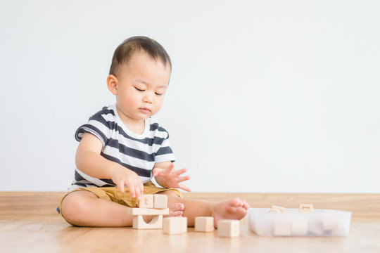 2 years baby boy.Little child boy playing with lots of wooden toys block with mother.Kids play with educational toys at home.Day care and Kindergarten school.child development concept.