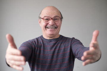 Free hugs for person who had bad day. Cheerfull father pulling hands towards camera, wanting to cuddle, smiling broadly, welcoming friend. Studio shot