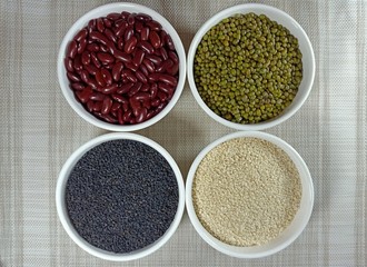  ired bean mung bean and black sesame white sesame in bowls on white background.