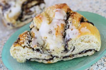 Sweet pastry with poppy seed glazed with icing sugar, closeup