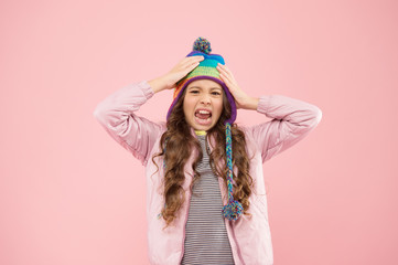 Preparing for winter. disgusted child pink background. kid fashion and shopping. girl. autumn style. happy childhood. small girl winter hat. ready for winter activity. warm clothes for cold season