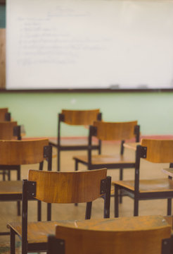 Lecture room or Examination room.School empty classroom with desks and chair for studying lessons and examination in school at Thailand.Interior of secondary education with whiteboard.vintage tone.