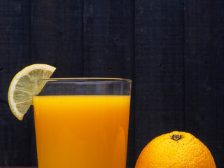 Orange juice with lemon on wood