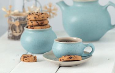 Obraz na płótnie Canvas Coffee with chocolate cookies in a blue ceramic cup on the background of Christmas accessories