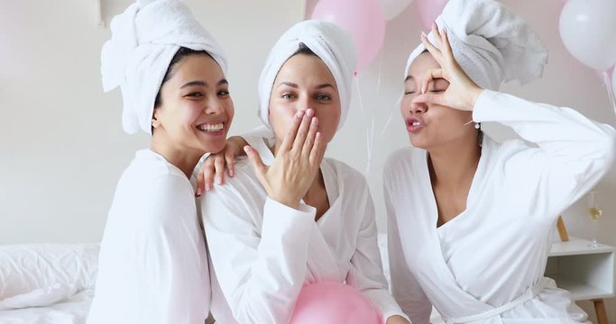Beautiful diverse girls look at camera gather on spa party