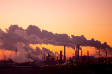 Defocus Violet smoke from the pipes at sunset, blurred industrial landscape. Environmental problems and air pollution