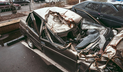 The body of the car is damaged as a result of an accident. High speed head on a car traffic accident. Dents on the car body after a collision on the highway