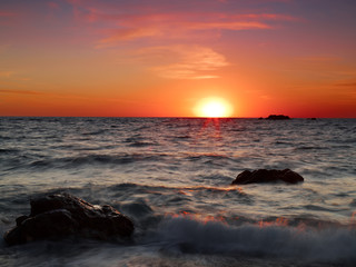 Fototapeta na wymiar The evening sun sets over the horizon on the sea