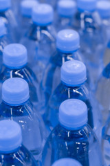Defocus background, pure drinking water in plastic bottles. Many drinks bottles in a supermarket