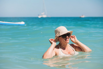 Fototapeta na wymiar Happy senior woman relaxing in Blue Lagoon. Mediterranean sea in Oludeniz, Turkey.