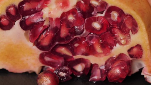 Extreme close up background of a red juicy ripe pomegranate fruit seeds, macro squeeze juice, vegan food