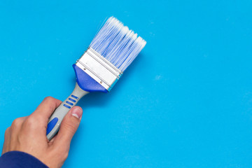 Creative concept, paint brush on blue background.