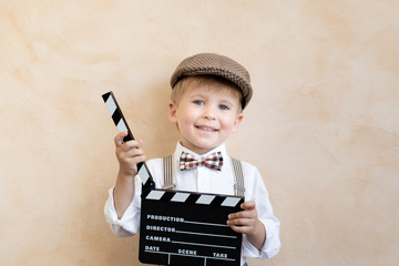 Funny kid holding clapper board