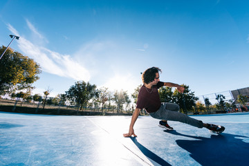 Young b boy dancing and posing at basketball court