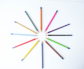 Pattern of colored pencils on a white background.